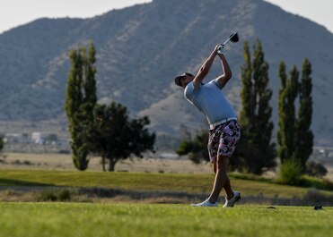 An Airman golfs.