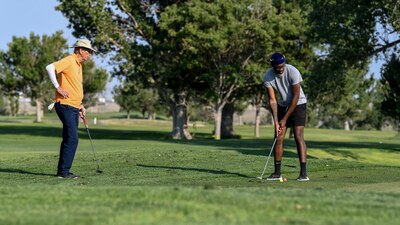 An Airman and retiree golf.