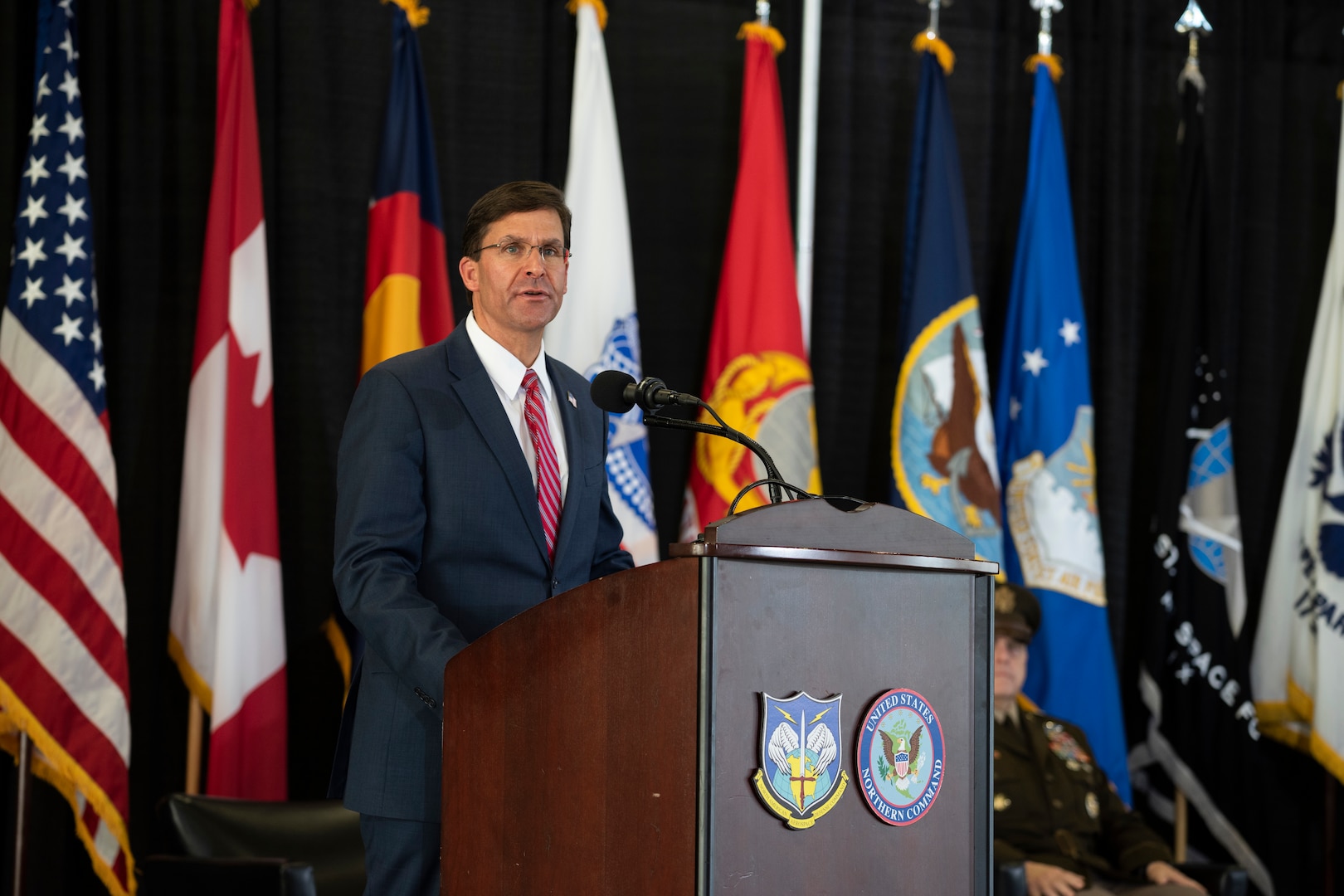 Defense Secretary Dr. Mark T. Esper speaks  from a stage.