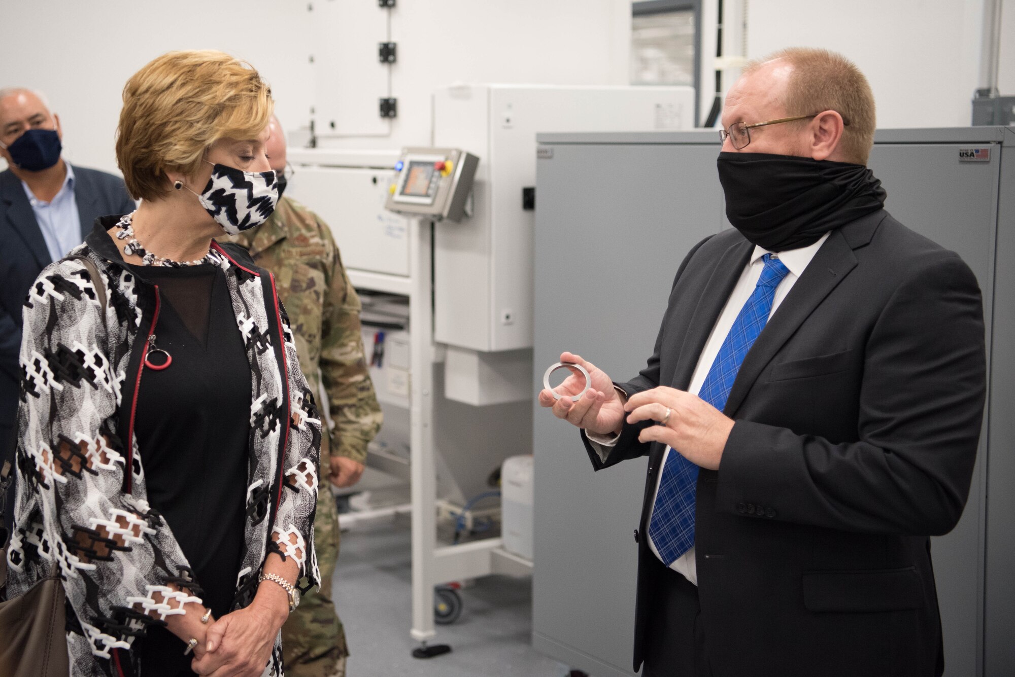 Hon. Lord looking at metal gasket held by Jason McCurry.