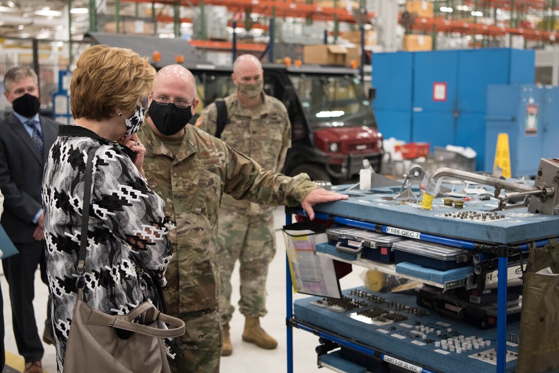 Hon. Lord looking at jet engine kit with Brig. Gen. King.