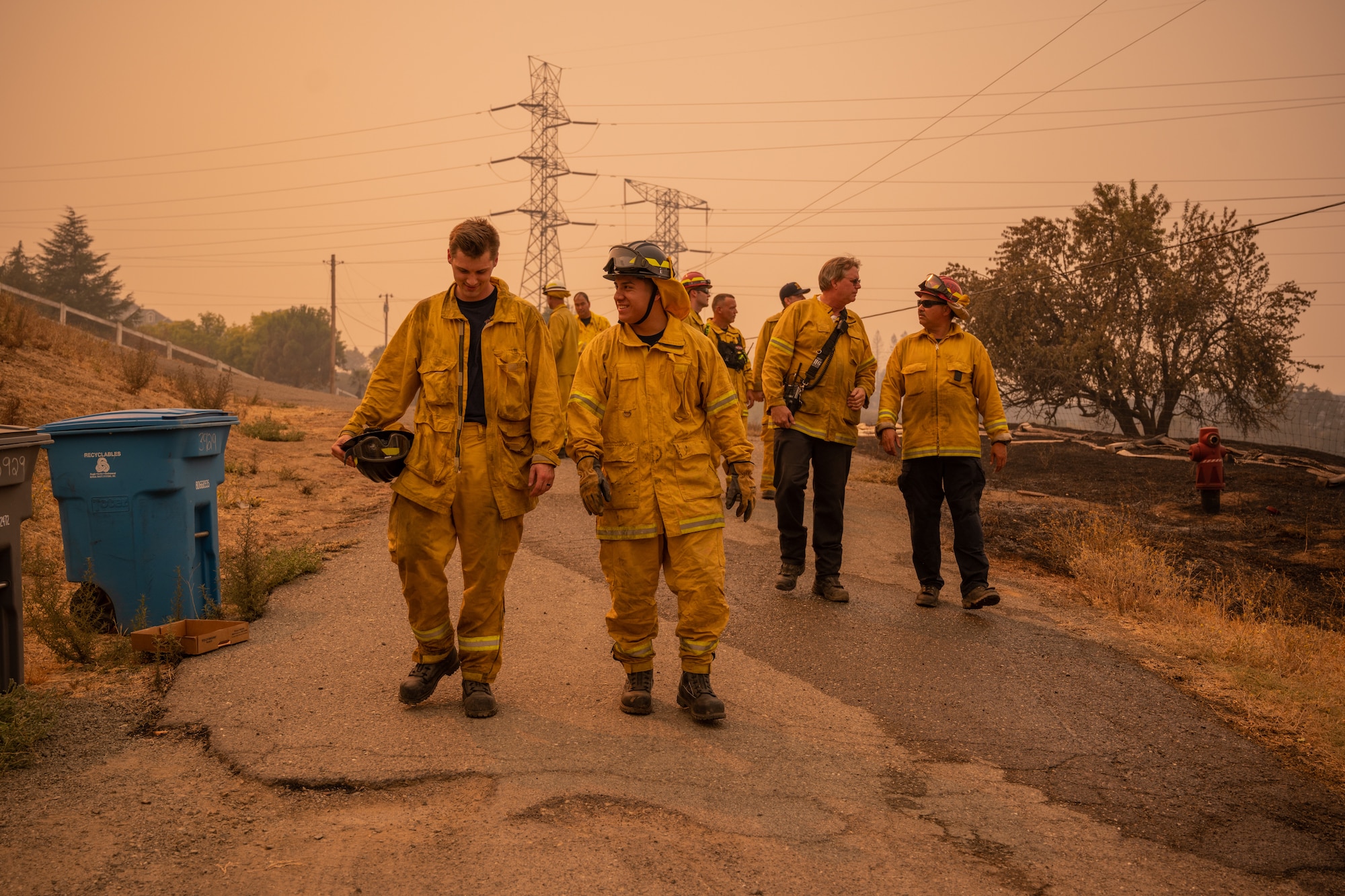 Firefighters walking on a road.