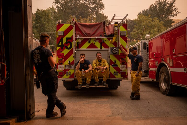 Firefighters sitting on the truck and standing by during a break.