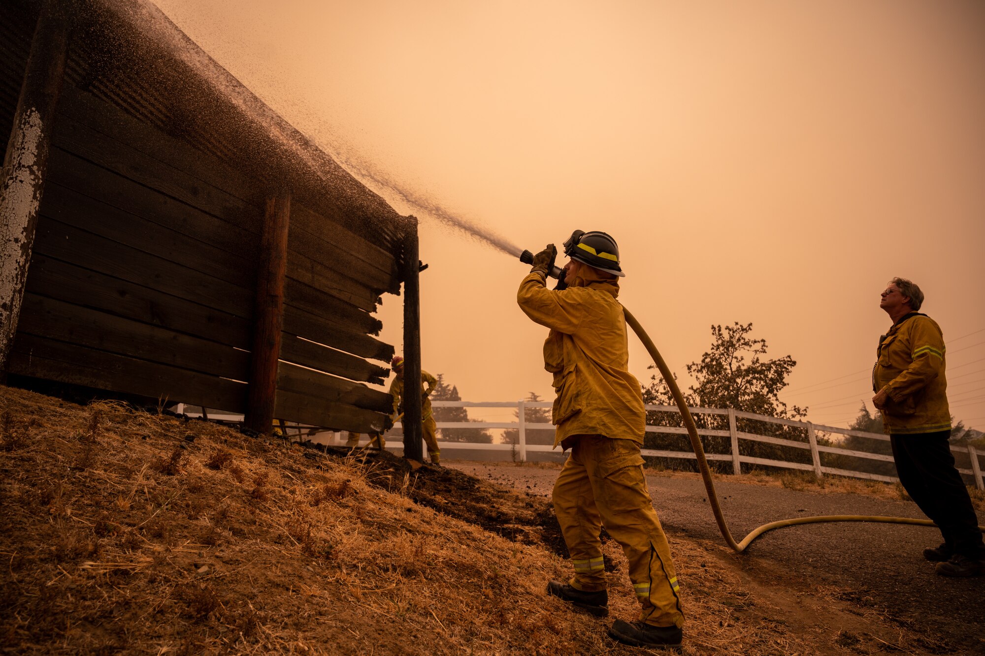 A firefighter puts out a fire with a hose.