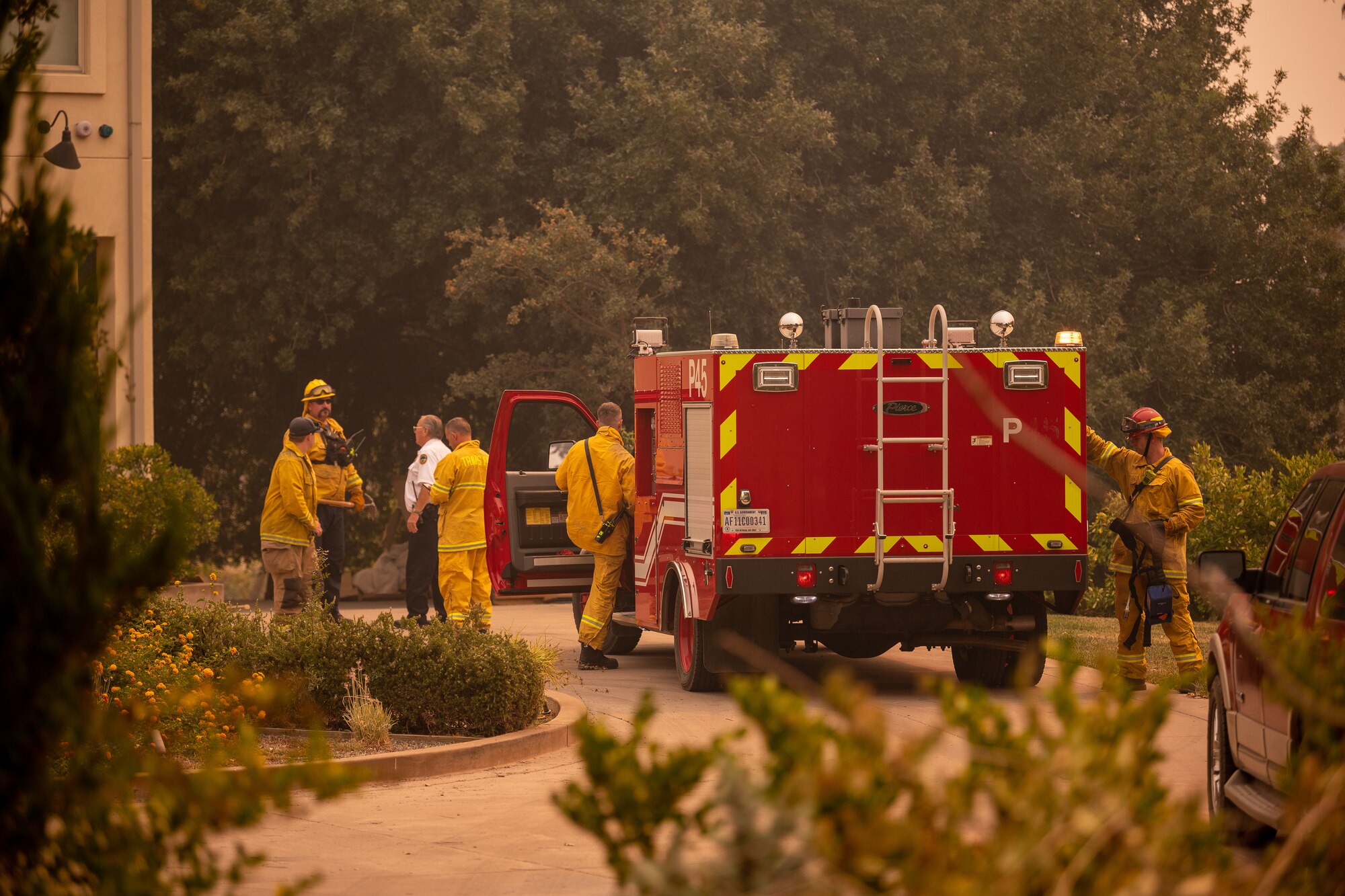 Firefighters standing around a firetruck preparing to go fight a fire.