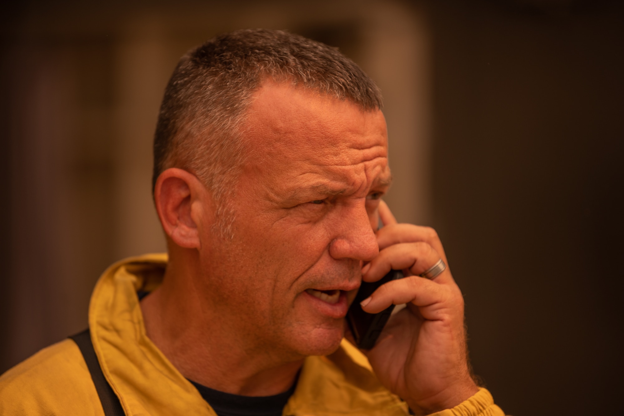 A fire chief talks on the phone about information regarding the fire.