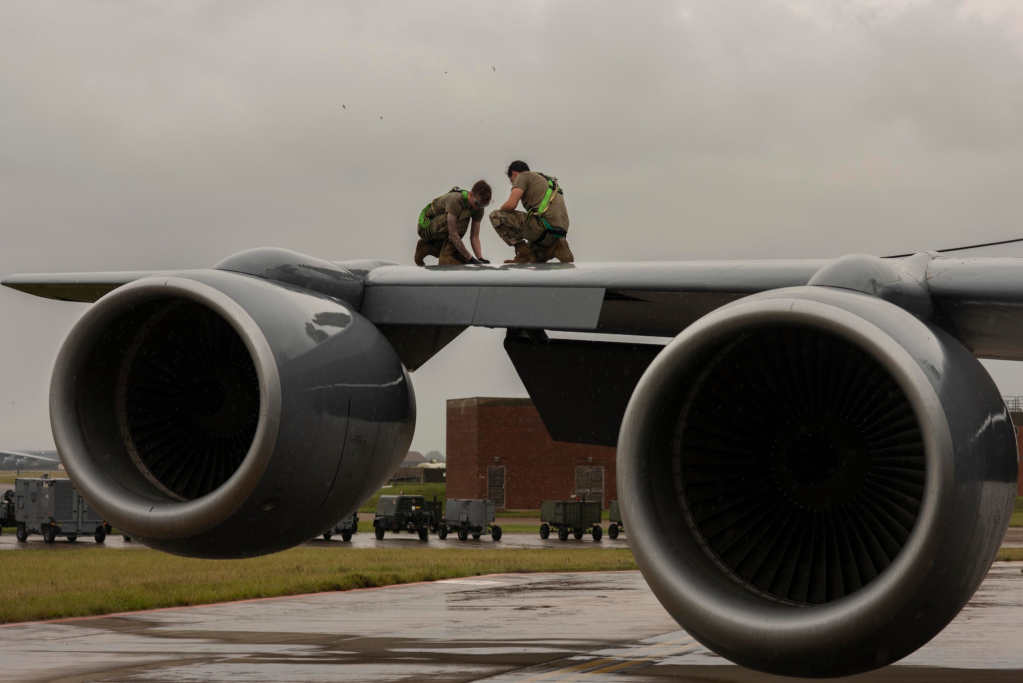 Senior Airman Liam Dennam, 100th Aircraft Maintenance Squadron aerospace propulsion journeyman, left, and Staff Sgt. Christian Herrera, 100th AMXS aerospace propulsion craftsman, service the right hydraulic system of a KC-135 Stratotanker aircraft before flight operations at Royal Air Force Mildenhall, England, Aug. 19, 2020. Maintenance operations support the readiness of aircraft to deliver aerial refueling throughout the U.S. Air Forces in Europe and Air Forces Africa theater. (U.S. Air Force photo by Airman 1st Class Joseph Barron)