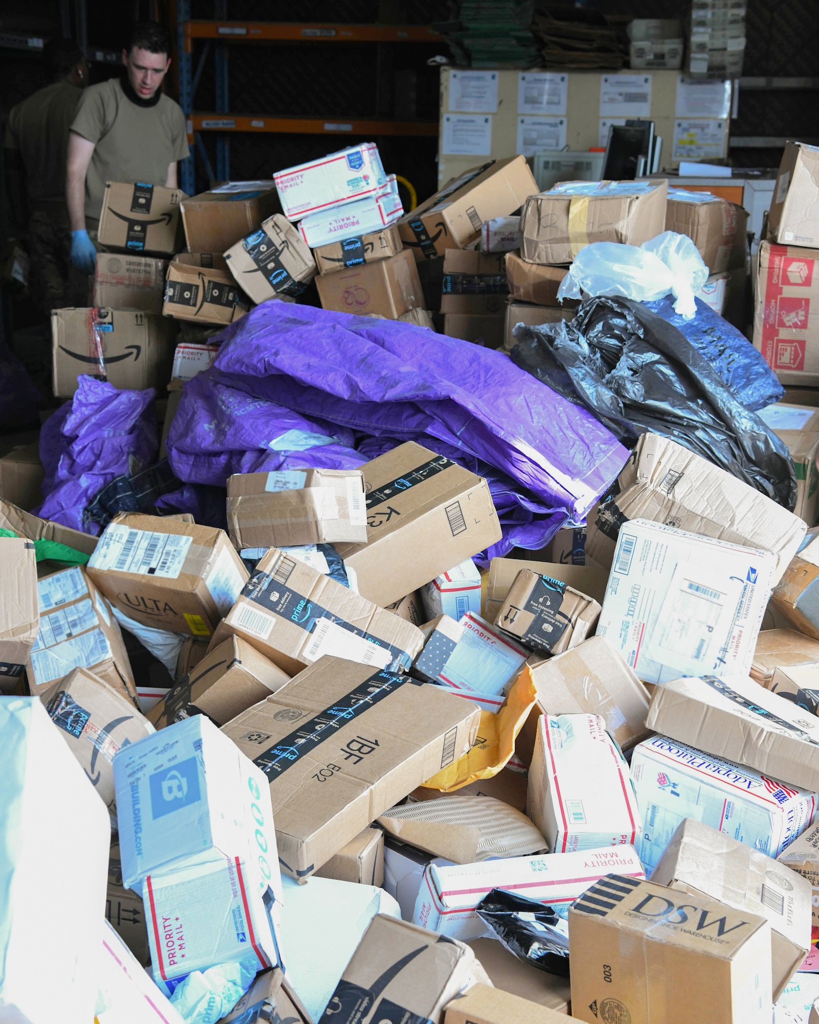 Tech. Sgt. David Harris, Al Dhafra Army Post Office postmaster, sorts packages with other Airmen at Al Dhafra Air Base, United Arab Emirates, July 23, 2020.