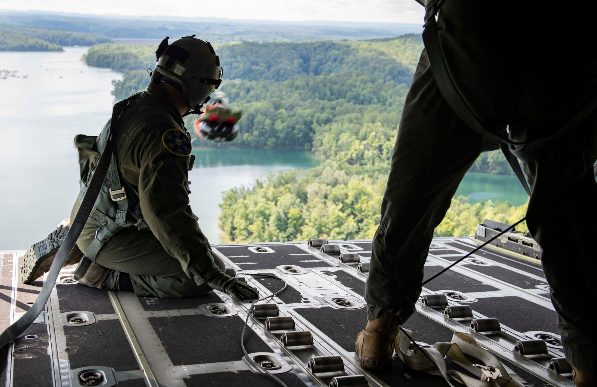 Air Force Reserve loadmasters watch cargo descend toward a drop zone after it is pushed out of the back of a C-130J Super Hercules near Charleston, W. Va., Aug. 23, 2020. Eight C-130s and Reserve and Guard partners converge to participate in a week-long training event. The exercise was designed to test the abilities of Air Force Reserve units to execute rapid global mobility missions in challenging, contested scenarios. (U.S. Air Force Reserve photo by Senior Airman Nathan Byrnes)