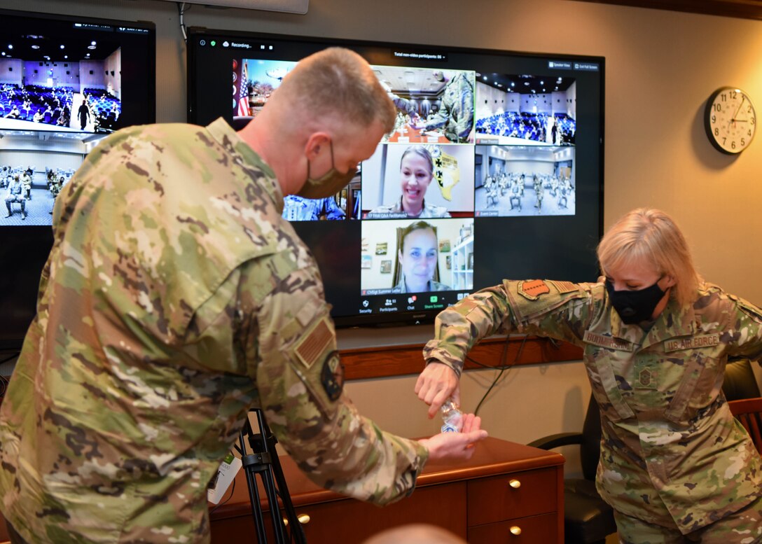 U.S. Air Force Chief Master Sgt. Casy Boomershine, 17th Training Wing command chief, presents a coin with no contact to Staff Sgt. Aaron Mount, 316th Training Squadron instructor, on behalf of Chief Master Sgt. Summer Leifer, 16 AF command chief at Goodfellow Air Force Base, Texas, Aug. 17, 2020. Mount was responsible for maintaining the resiliency of 400 Airmen restricted to base by hosting two comedy shows. (U.S. Air Force photo by Airman 1st Class Ethan Sherwood)