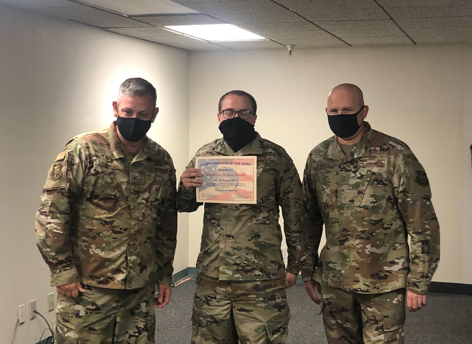 An airman receives an award being presenting by leadership.