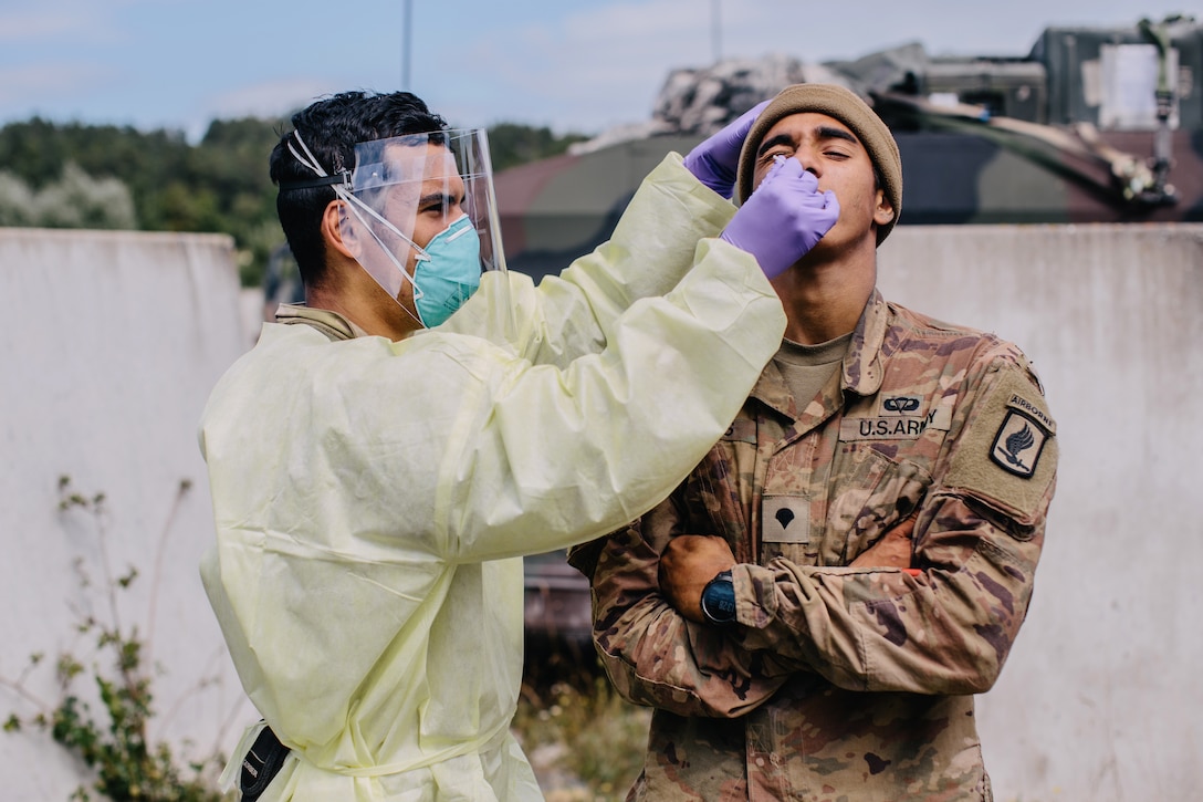 An Army medic swabs a solider for COVID-19.