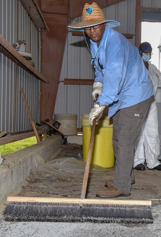Byron McCrey, an environmental protection specialist assigned to the 628th Civil Engineer Squadron Installation Management Flight Environmental Management Element, uses Oil-Dri to clean up spilled oil-based materials dropped off from the USNS Charlton (T-AKR-314) at Joint Base Charleston, S.C., July 31, 2020. Members of the 628th CES Installation Management Flight Environmental Management Element receive hazardous waste from different areas of Joint Base Charleston. Their mission is to dispose of the waste properly to keep the environment and the local community safe.