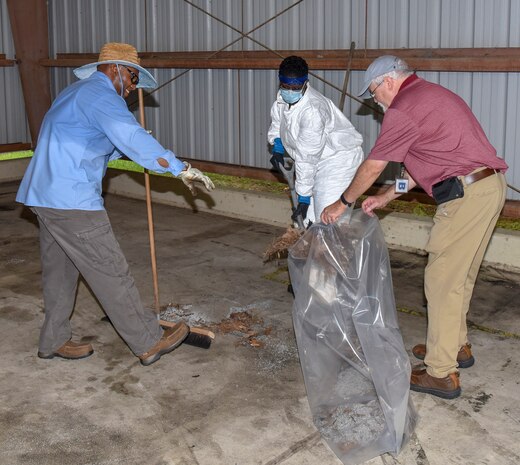 Byron McCrey, an environmental protection specialist assigned to the 628th Civil Engineer Squadron Installation Management Flight Environmental Management Element (left), Marsha K. Singleton, an environmental protection specialist assigned to the 628th CES Installation Flight (middle) and Berry Lewis, 628th CES Installation Management Flight Environmental Management Element chief (right), clean up spilled oil-based materials dropped off from the USNS Charlton (T-AKR-314) at Joint Base Charleston, S.C., July 31, 2020. Members of the 628th CES Installation Management Flight Environmental Management Element receive hazardous waste from different areas of Joint Base Charleston. Their mission is to dispose of the waste properly to keep the environment and the local community safe.