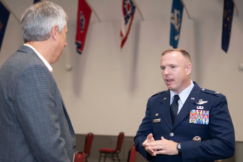 Col. Anderson in dress blues speaking with another person.