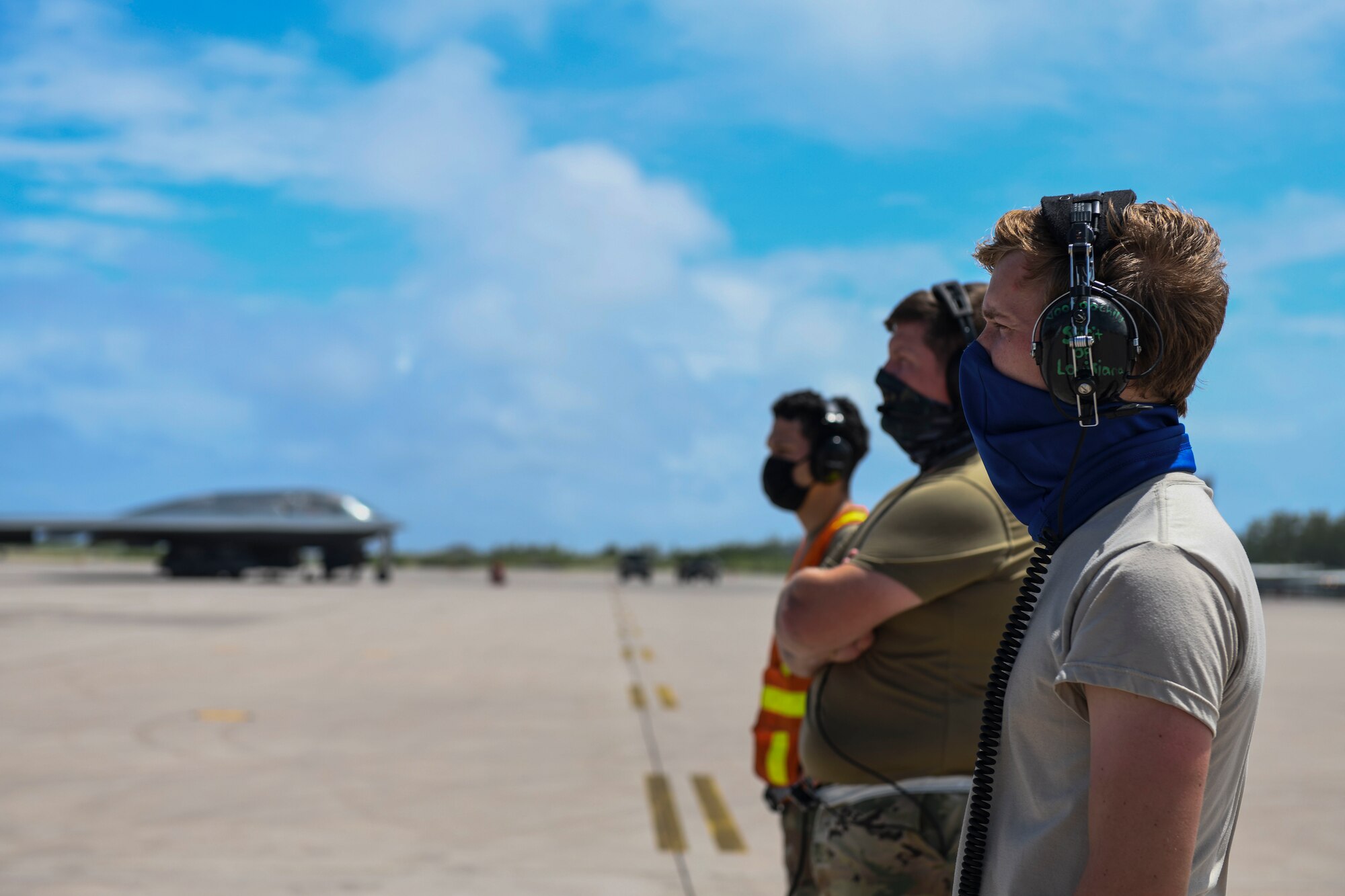 U.S. Air Force Airman 1st Class Samuel Medina, Staff Sgt. Mark Farrar, and Senior Airman Robert Witkowski, maintainers assigned to the 393rd Expeditionary Bomb Squadron, deployed from Whiteman Air Force Base, Missouri, prepare to marshal a B-2 Spirit Stealth Bomber at Naval Support Facility Diego Garcia, to support a bomber task force mission,  Aug. 17, 2020. Due to COVID-19 restrictions, deployed members actively employed social distancing measures and mask wearing in order to continue operating U.S. Strategic Command’s dynamic force employment missions in the Indo-Pacific. (U.S. Air Force photo by Tech. Sgt. Heather Salazar)