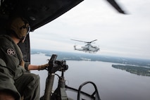 Cpl. Bryce Hawkins, an aerial observer with Marine Light Attack Helicopter Squadron 269, flies in a UH-1Y Huey next to an AH-1Z Viper during Exercise Deep Water 2020 over Marine Corps Air Station New River, North Carolina, July 29, 2020. The purpose of the exercise is to increase 2nd Marine Aircraft Wing's interoperability and readiness on a scale that simulates peer-level threats. (U.S Marine Corps Photo by Cpl. Juan C. Dominguez)