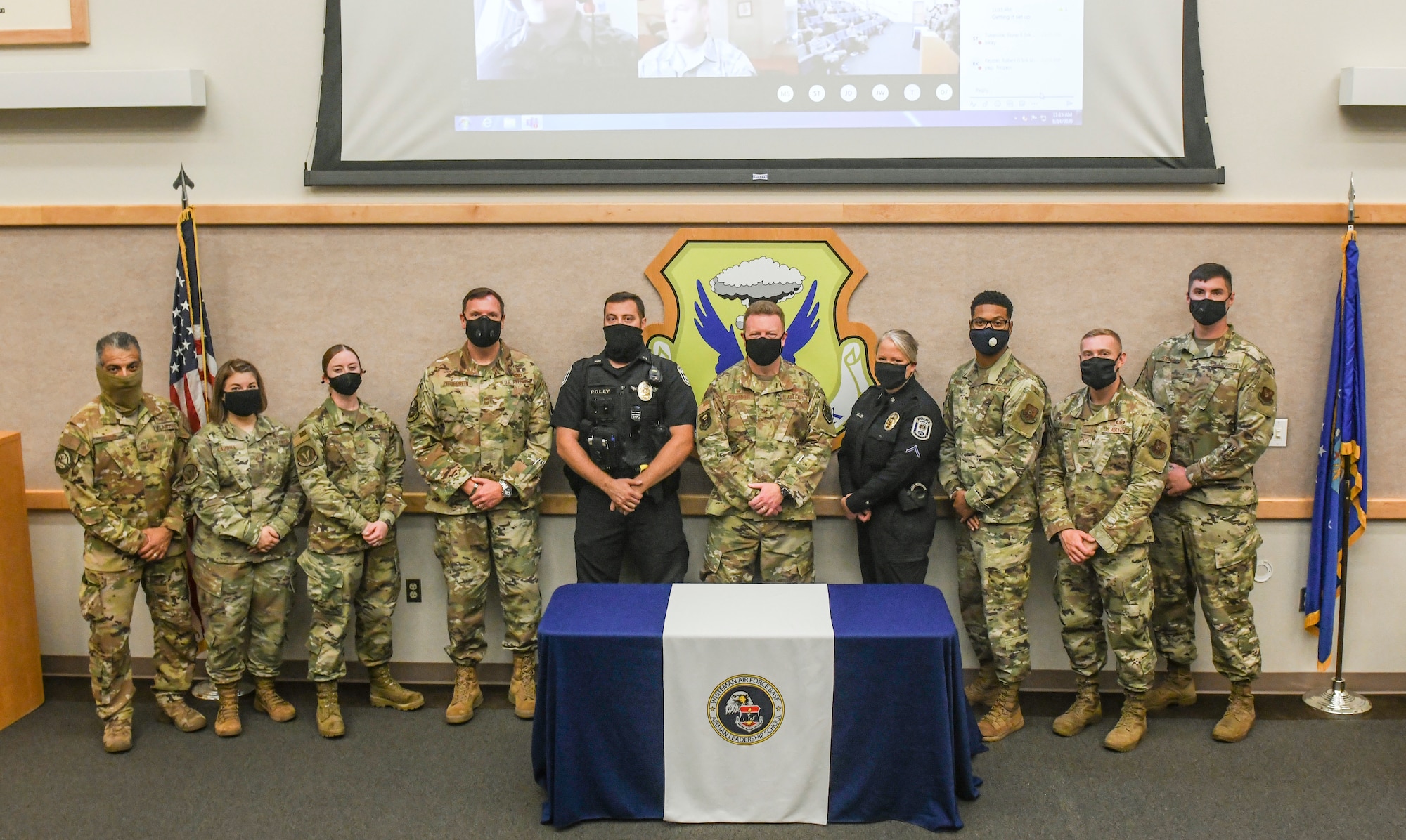 U.S. Air Force Col. Jeffrey Schreiner, 509th Bomb Wing commander, center, Airman Leadership School instructors and members of the Warrensburg Police Department, stand for a photo, Aug. 14, 2020, at Whiteman Air Force Base, Missouri. For the first time, Whiteman AFB’s ALS class included two local law enforcement personnel who attended the leadership course and earned certificates of completion. Airman Leadership School is the first level of the Enlisted Professional Military Education continuum and prepares Senior Airmen to be professional, war-fighting Airmen and Space professionals who can supervise and lead work teams. (U.S. Air Force photo by Staff Sgt. Sadie Colbert)