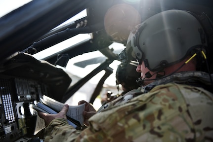 U.S. Army Chief Warrant Officer 2 Kristopher Pinson, a pilot assigned to the 1st Battalion 228th Aviation Regiment Air Ambulance Detachment at Joint Task Force-Bravo, checks his pre-flight technical orders at Soto Cano Air Base, Honduras July 31, 2020. The Charlie Company of the 1-228th have been vital in providing emergency medical transportation throughout Honduras. Pinson served as a co-pilot in the second aeromedical evacuation mission.