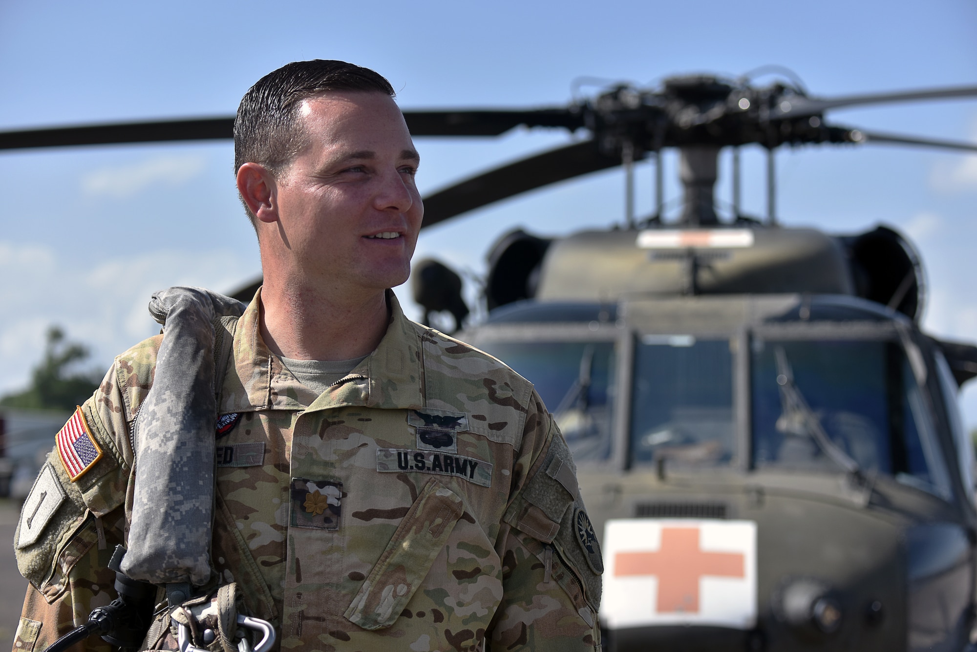 U.S. Army Maj. Cody Sneed, the 1st Battalion 228th Aviation Regiment Joint Task Force-Bravo Charlie Company commander, stands in front of a UH-60 Blackhawk at Soto Cano Air Base, Honduras July 31, 2020. The Charlie Company of the 1-228th have been vital in providing emergency medical transportation throughout Honduras.