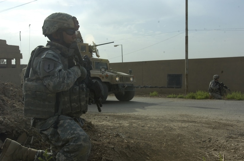 A soldier kneels while on patrol.