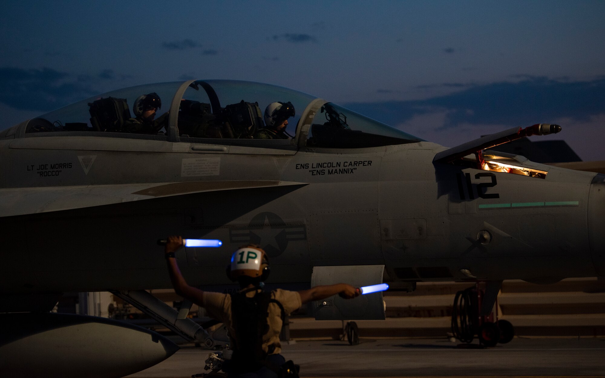 Sailor signals to aircraft on the flight line.