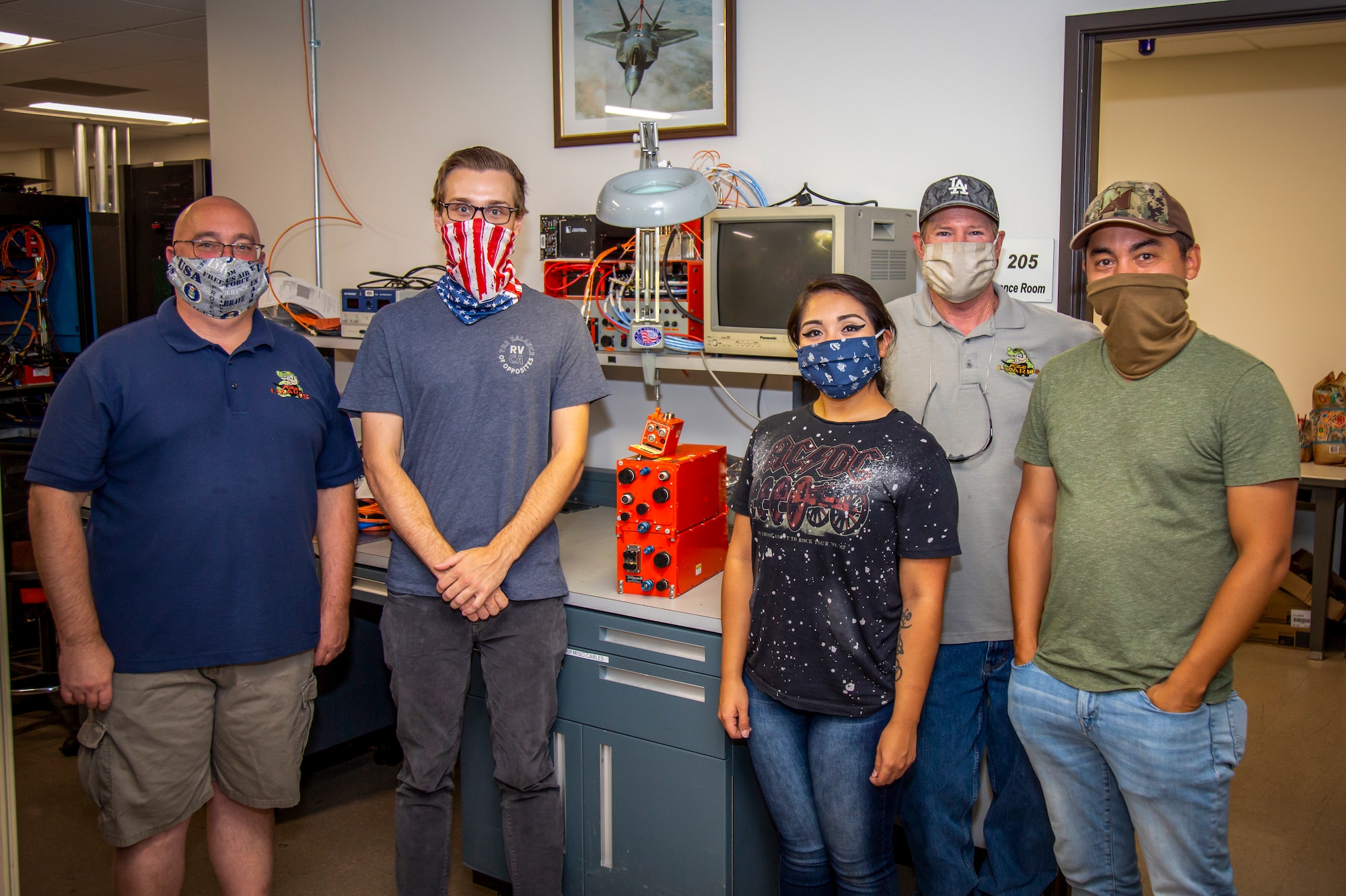 The 411th Flight Test Squadron instrumentation team: Brian Bock, Jackson Greaves, Valerie Galvan, Mike Burgess and James Lee (left to right) pose for a photo with a Common Range Integrated Instrumentation System module at Edwards Air Force Base, Aug. 19. The CRIIS was successfully integrated into a 411th FLTS F-22 Raptor, Aug. 5. (Photo courtesy of Kyle Larson, Lockheed Martin)