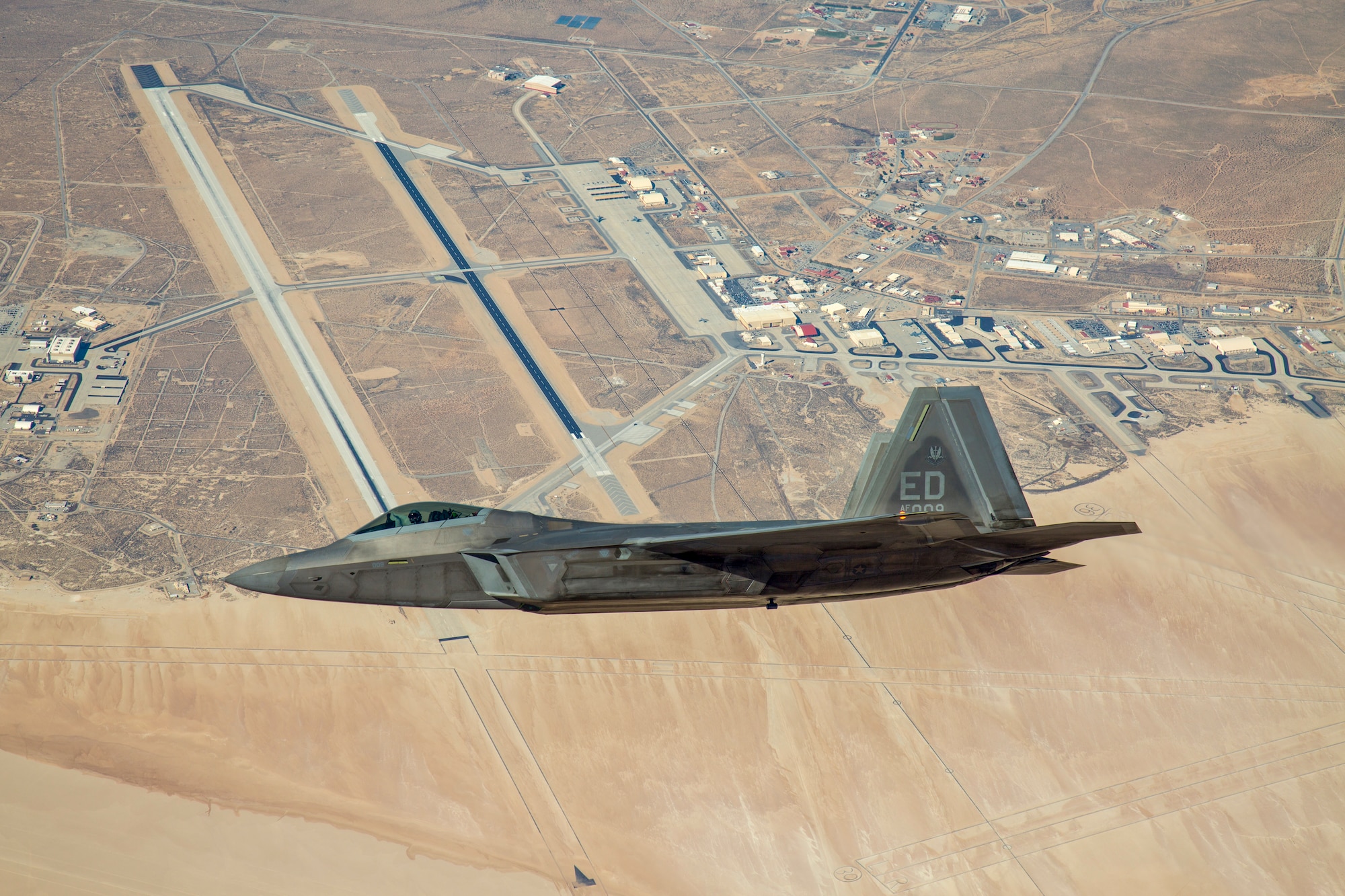 An F-22 Raptor assigned to the 411th Flight Test Squadron flies over Edwards Air Force Base, California, in 2018. The 411th FLTS successfully integrated the Common Range Integrated Instrumentation System (CRIIS) during a test flight Aug. 5 (Photo courtesy of Christopher Higgins, Lockheed Martin)
