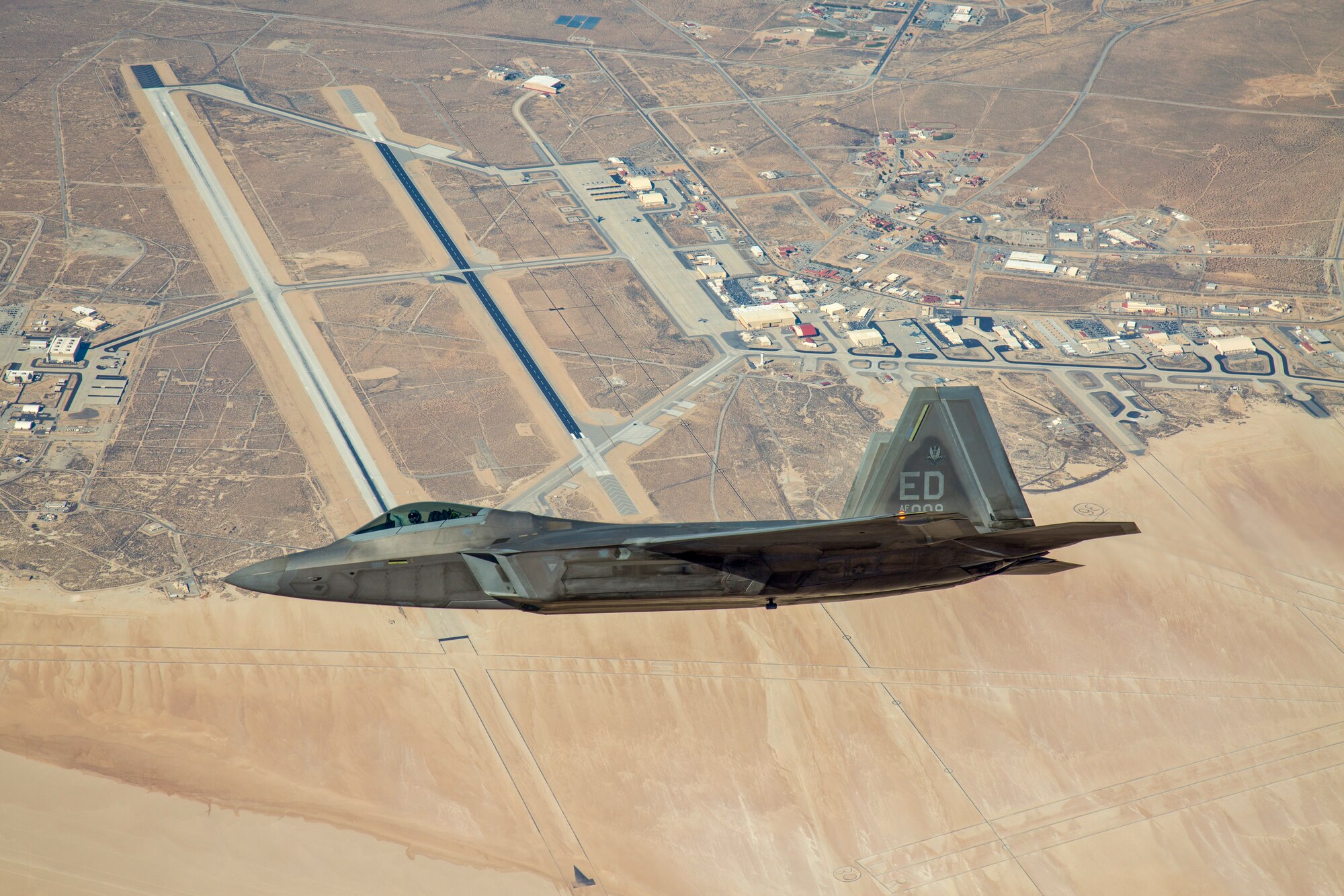 An F-22 Raptor assigned to the 411th Flight Test Squadron flies over Edwards Air Force Base, California, in 2018. The 411th FLTS successfully integrated the Common Range Integrated Instrumentation System (CRIIS) during a test flight Aug. 5 (Photo courtesy of Christopher Higgins, Lockheed Martin)