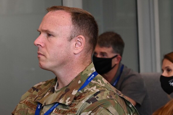 Photo of Col David Anderson looking on in an audience.