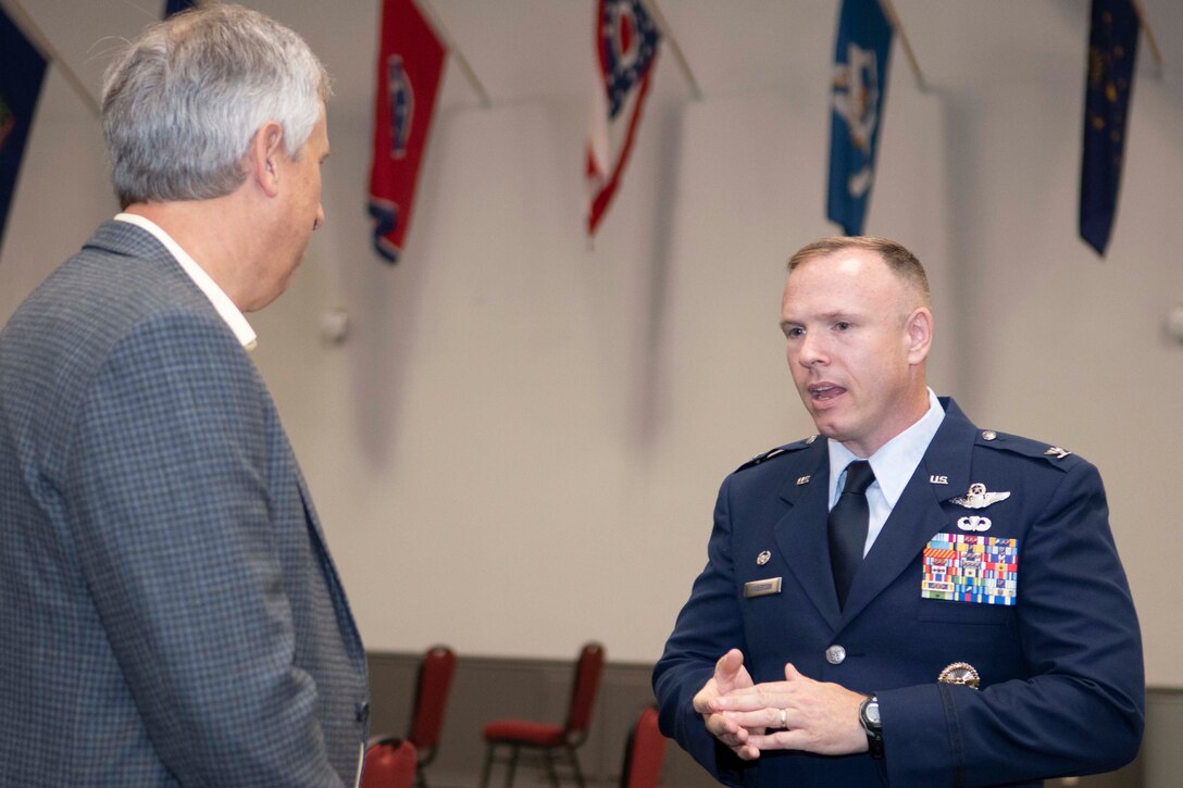 Col. Anderson in dress blues speaking with another person.