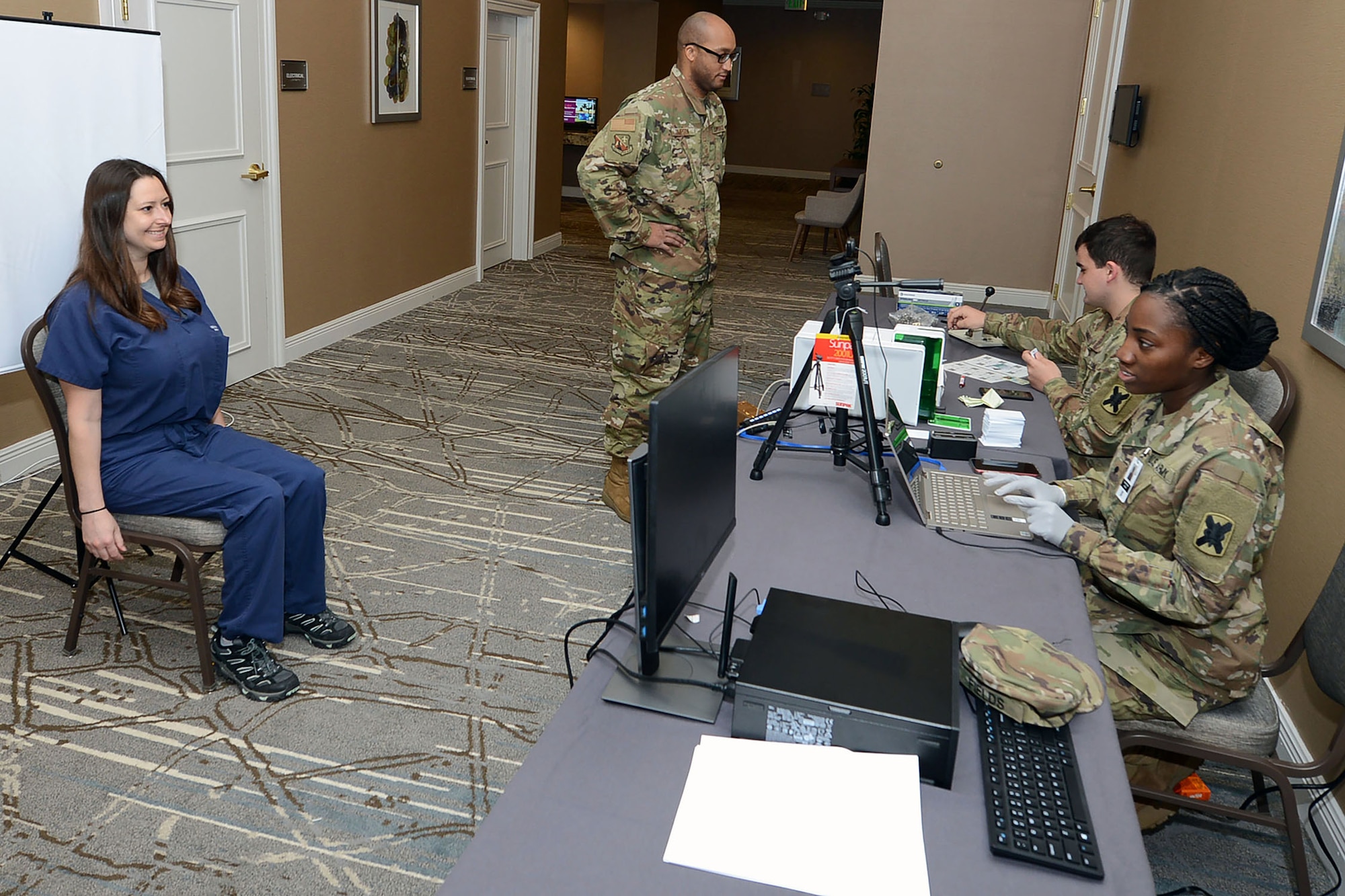 Spc. Shunterika Fields and Army Pvt. Stephen Hines create ID cards to track non-patient personnel’s temperatures at the temporary medical facility in New Orleans, April 4.