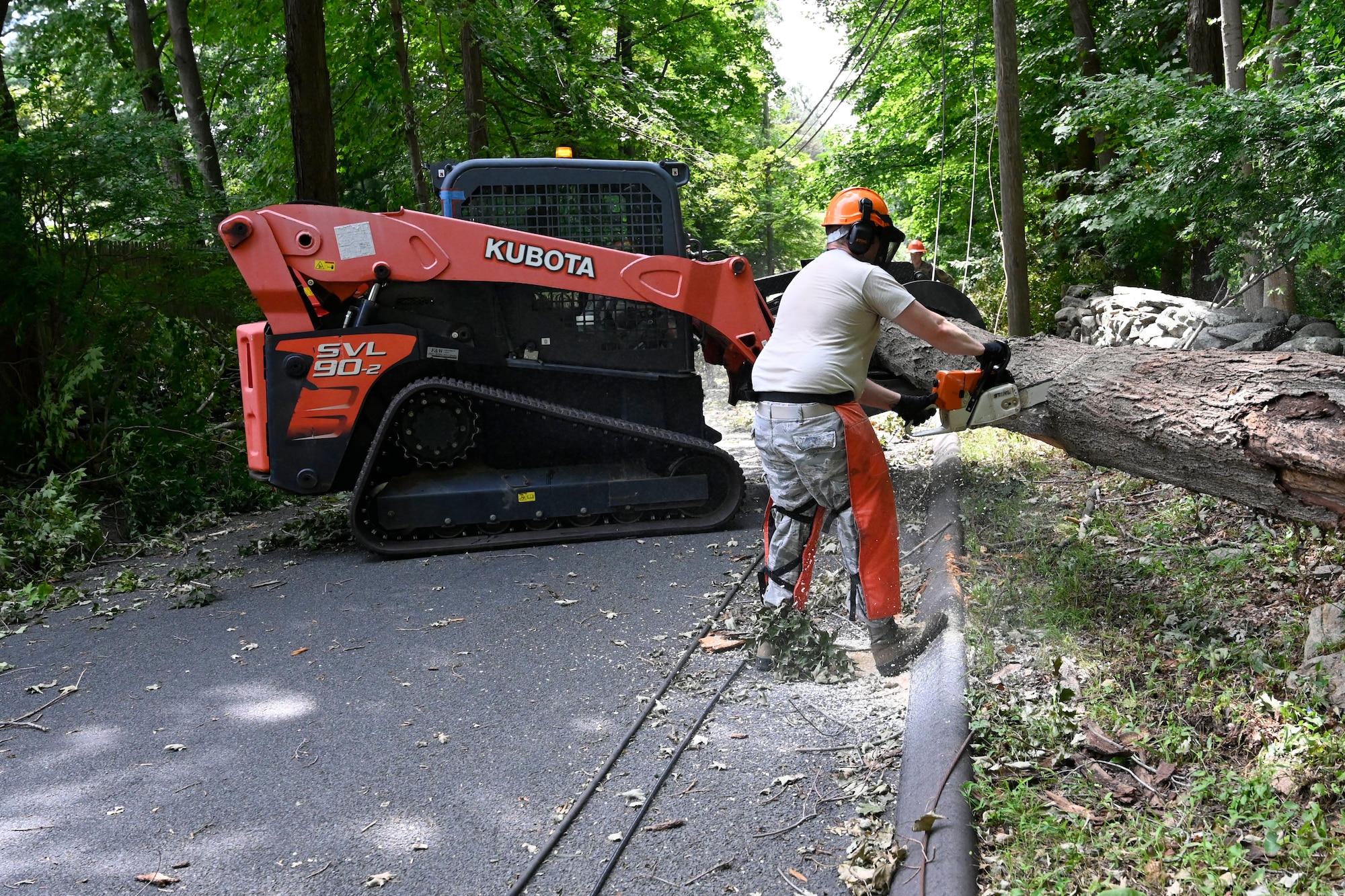Air Force Master Sgt. Jon Delaney, member of the 103rd Civil Engineer Squadron, uses a chainsaw to cut a tree that fell into a roadway during Hurricane Isaias, August 7, 2020, Fairfield, Connecticut. Delaney and other members of the 103rd CES removed fallen trees and other debris  from roadways as part of Connecticut's emergency response to Isaias. (U.S. Air National Guard photo by Tech. Sgt. Tamara R. Dabney)