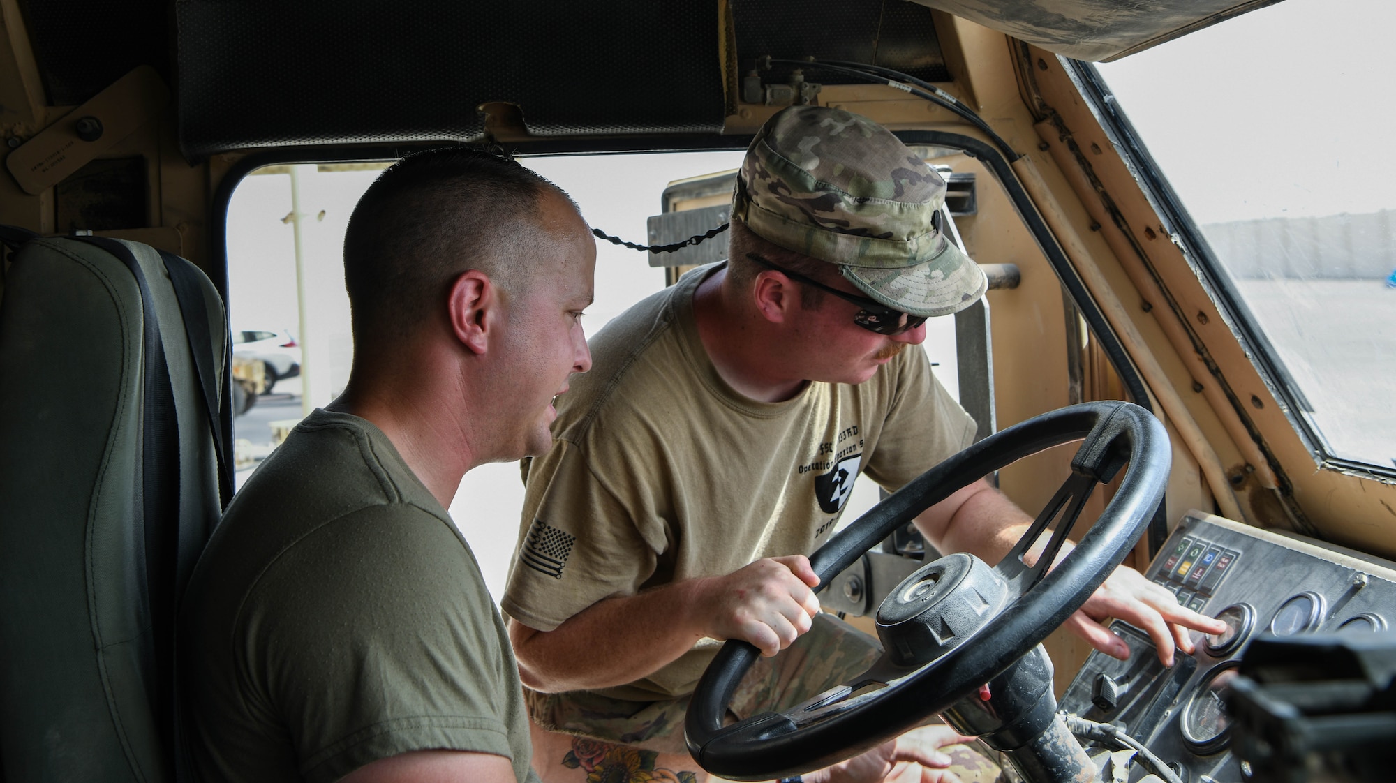 Army Specialist David Chaffin, instructor for the 133rd Battalion, shows Air Force Senior Airman Aiden Penrod, 380th Expeditionary Logistics Readiness Squadron ground transportation apprentice, the instrument panel of the M1075 Palletized Load System, July 22, 2020 at Al Dhafra Air Base, United Arab Emirates.