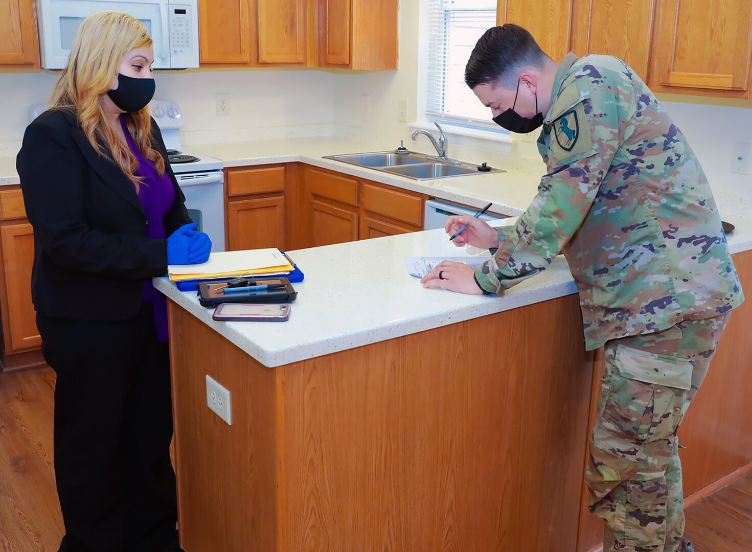 A newly assigned drill sergeant with the 199th Infantry Brigade approves a move-in inspection form at his new home on Fort Benning, Georgia, June 25, 2020.