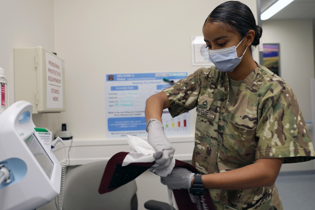 Army Pfc. Destiny Buenavente, a combat medic specialist assigned to Kleber Army Health Clinic, disinfects a blood pressure monitor following a patient's medical examination July 30, 2020 in Kaiserslautern, Germany. Defense Logistics Agency’s Electronic Catalog Program, an ecommerce platform where customers can browse, compare and order medical implants, laboratory, dental, optical fabrication, and commercial medical and surgical equipment items, received the Office of Management and Budget Best-In-Class designation August 19, 2020.