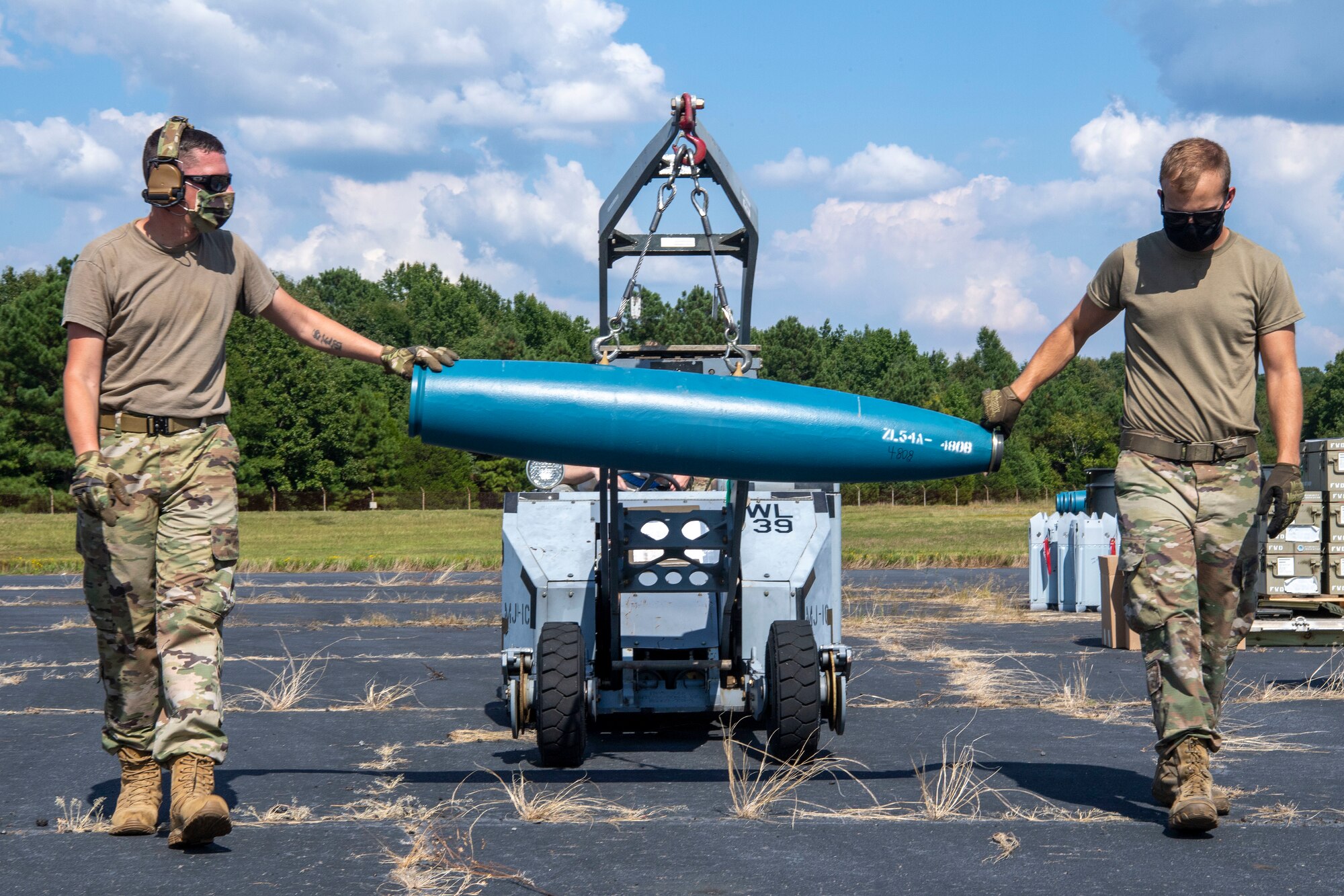 Airmen move an inert munition
