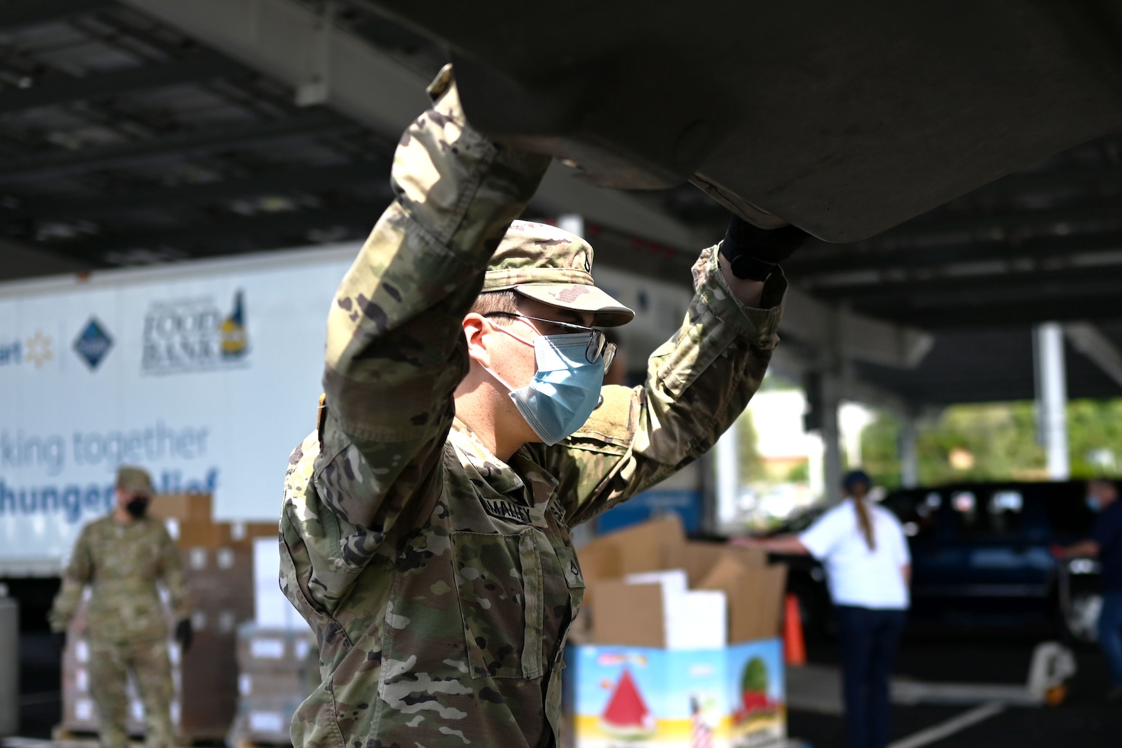 Pfc. Logan O'Malley, 3643d Brigade Support Battalion, NHARNG, loads a car with food on Aug. 7, 2020, at a mobile pantry drive-thru in Manchester.