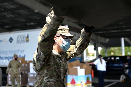 Pfc. Logan O'Malley, 3643d Brigade Support Battalion, NHARNG, loads a car with food on Aug. 7, 2020, at a mobile pantry drive-thru in Manchester.