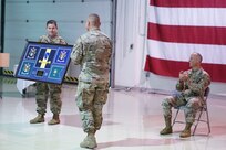 Alaska Army National Guard Maj. Michael Riley, 38th Troop Command adjutant, presents Col. Joel Gilbert, former 38th TC commander, with a gift during an Aug. 2, 2020, change-of-command ceremony at Joint Base Elmendorf-Richardson. Lt. Col. Tim Brower (right) succeeded Gilbert during the ceremony. (U.S. Army National Guard photo by Capt. David Bedard/Released)