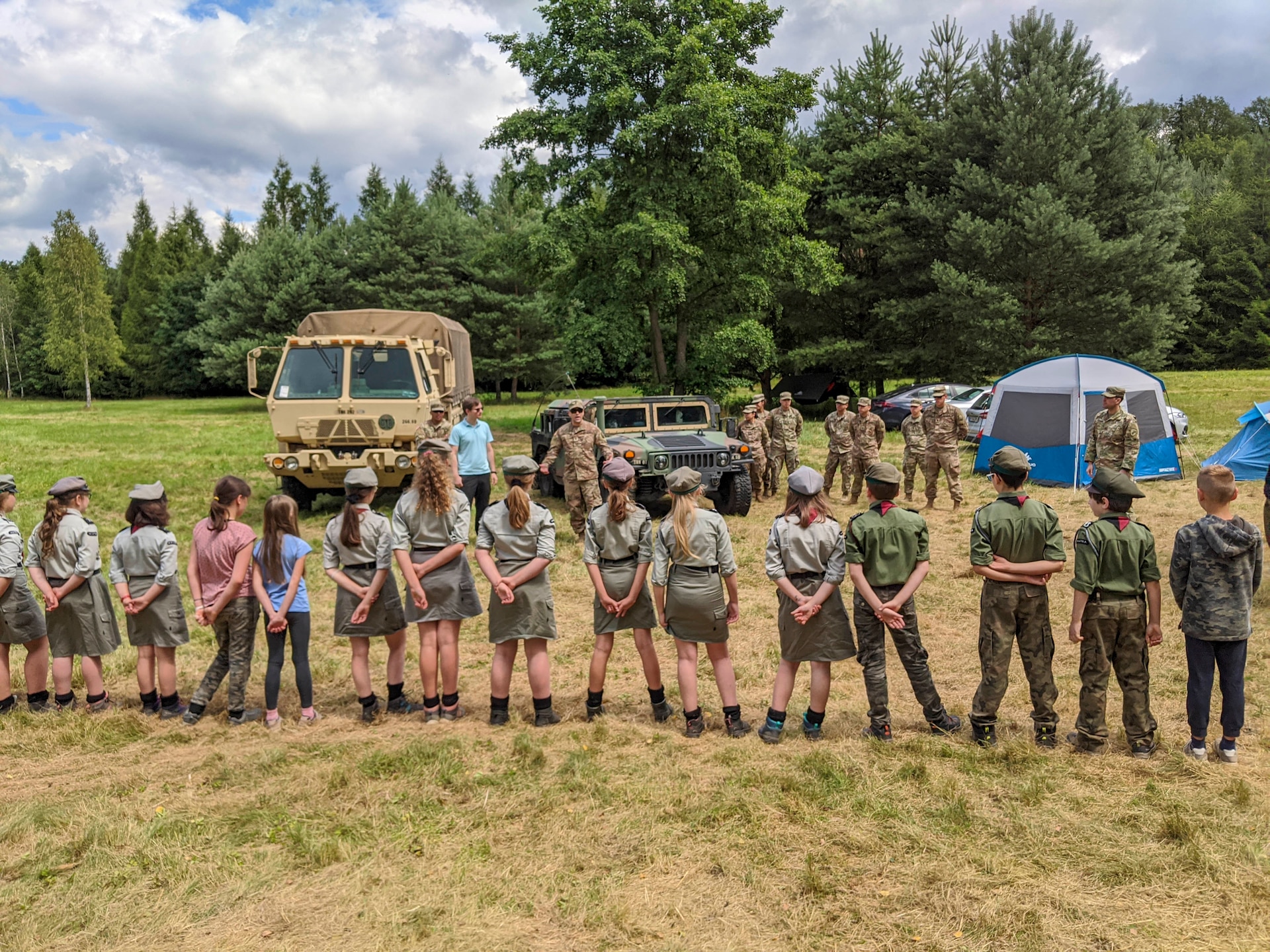 U.S. Army 1st Lt. Eduardo Santiago, detachment commander for the 266th Ordinance Company, a Reserve unit out of Puerto Rico, speaks with Polish scouts about his unit’s mission in support of Atlantic Resolve at Camp Watra near Osieczow, Poland, July 17, 2020.  U.S. Army Soldiers from the Alaska National Guard’s 297th Regional Support Group and U.S. Army Reserve’s Bravo Company, 418th Civil Affairs Battalion, out of Missouri, joined the 266th OD to learn about the history and values of the Polish scouting organization while sharing their units’ missions and high-mobility multipurpose wheeled and medium tactical vehicles that are assigned to nearby FOS Świętoszów.