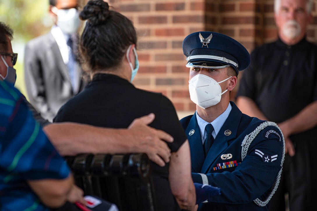 Airman 1st Class Ryan Furtado, 7th Force Support Squadron honor guardsman, presents a folded flag to the deceased’s next-of-kin during a standard honors funeral at Texas State Veterans Cemetery at Abilene in Abilene, Texas, Aug. 10, 2020. The presentation of the flag to the next-of-kin serves as a keepsake that symbolizes the service and dedication that military members give to their country. (U.S. Air Force photo by Airman 1st Class Colin Hollowell)