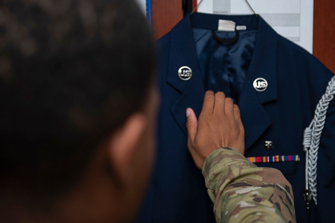 Airman 1st Class Jaidan Lanier, 7th Force Support Squadron honor guardsman, reaches for his uniform at Dyess Air Force Base, Texas, Aug. 11, 2020. The Dyess AFB honor guard performs traditional services during official ceremonies and military funerals. (U.S. Air Force photo by Airman 1st Class Colin Hollowell)