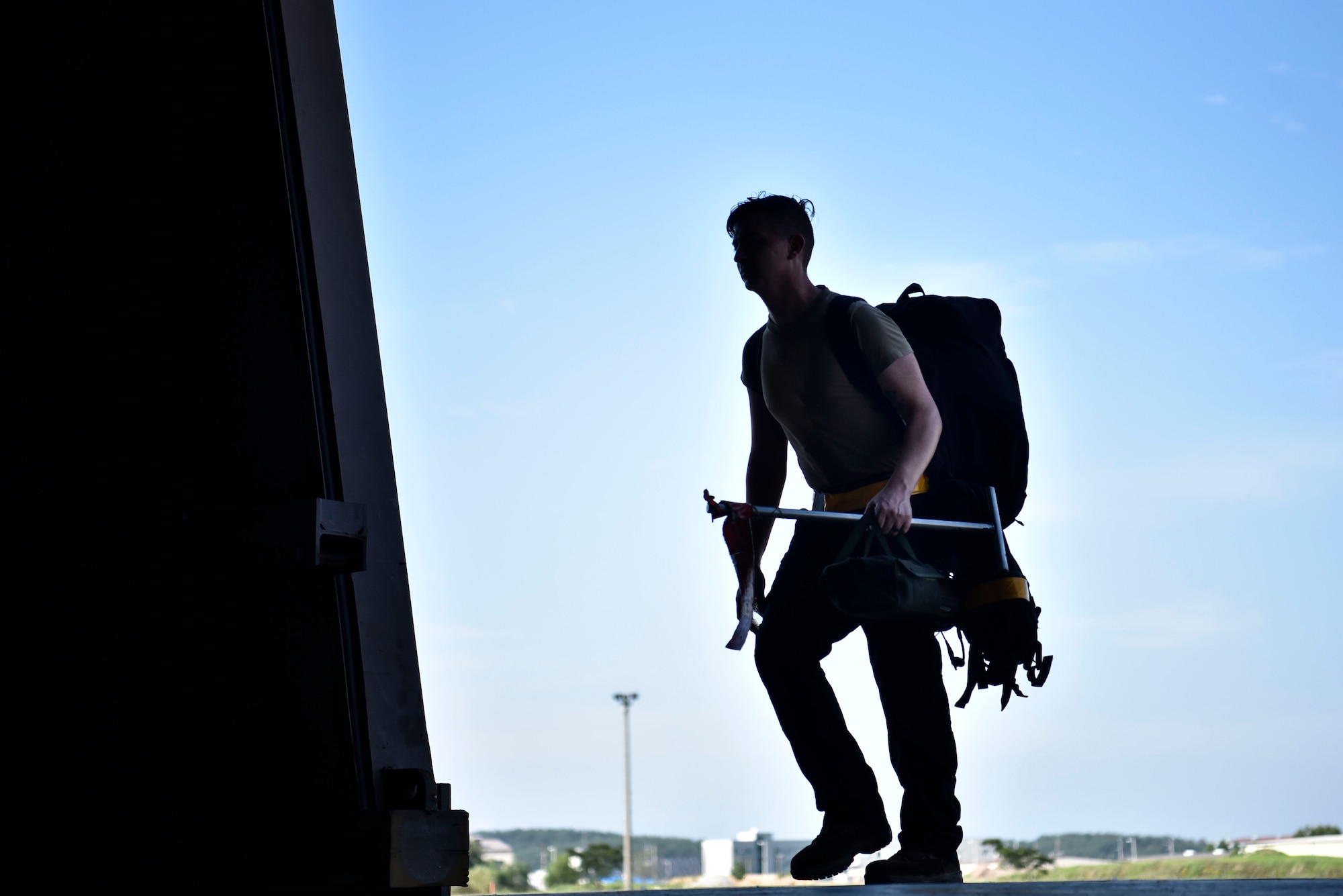 A photo of an Airman walking into a hangar.