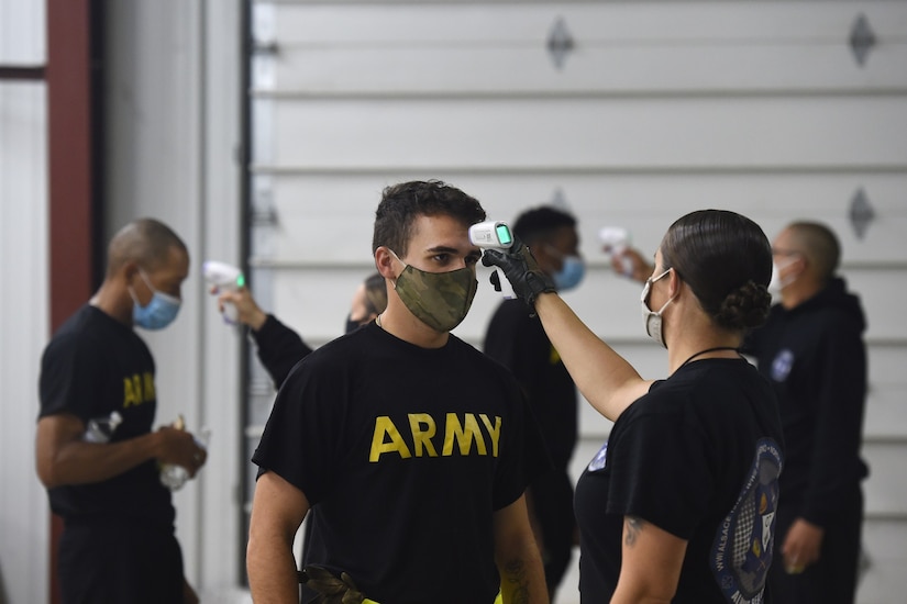 Observer coach/trainers, under First Army’s 181st Multi-functional Training Brigade, conduct temperature checks on arriving Soldiers before an Army Combat Fitness Test familiarization at Operation Ready Warrior exercise, at Fort McCoy, Wisconsin, August 23, 2020.