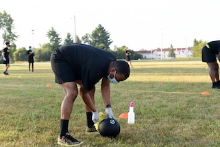 An Army Reserve Soldier sanitizes a 10-pound medicine ball after he uses it for the Standing Power Throw, one of six test events for the Army Combat Fitness Test, during Operation Ready Warrior exercise, at Fort McCoy, Wisconsin, August 23, 2020.