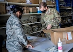 Airman 1st Class Jason Larose, materiel handler from the 103rd Logistics Readiness Squadron, supplies a box of operational camouflage pattern uniforms to an Airman, at Bradley Air National Guard Base, East Granby, Connecticut Aug. 22, 2020. The 103rd LRS prepared boxes filled with two sets of OCPs, to be distributed to Airmen. The transition from the air battle uniform to the OCP is expected to be completed by 2021. (U.S. Air National Guard photo by Senior Airman Chanhda Ly)