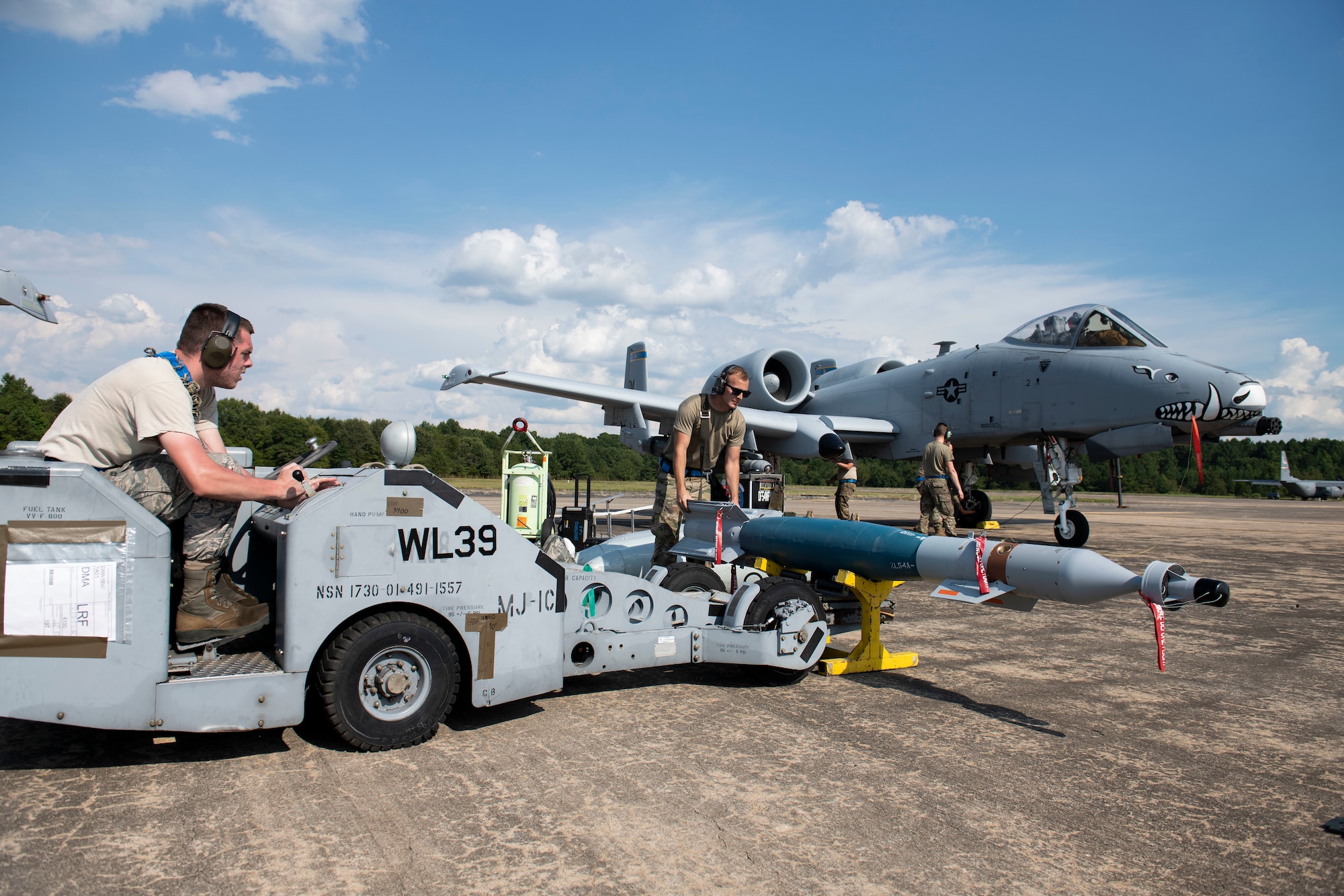 Airmen prepare to load an inert munition onto an aircraft