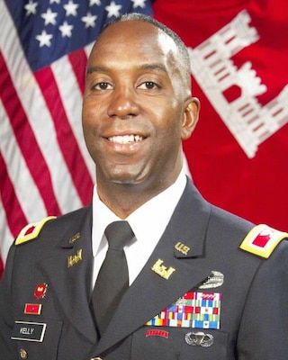 Man smiles against backdrop of American flags.