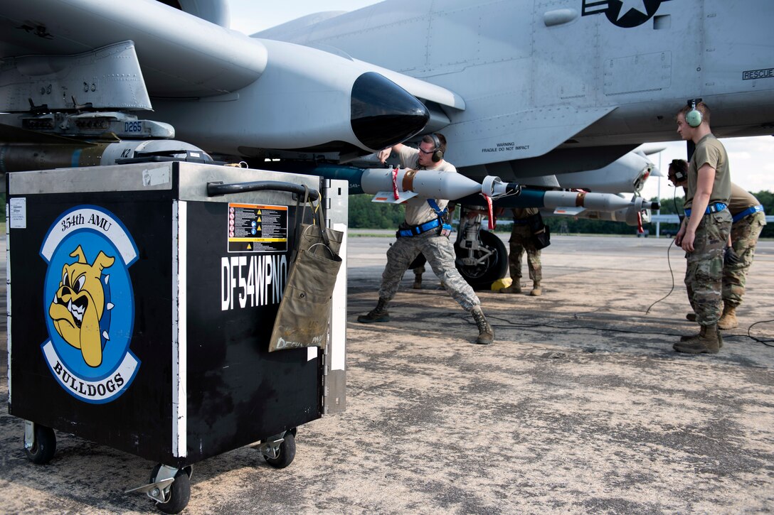 Airmen load an inert munition onto an aircraft